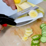 Tijera pelador cortador de verduras en acción, rebanando plátano y mostrando rebanadas de pepino y chile.