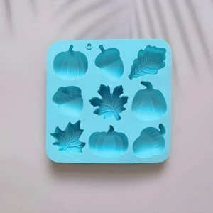 Molde de silicona azul para repostería con nueve cavidades de motivos otoñales, incluyendo calabazas, bellotas y hojas de arce para uso artesanal.