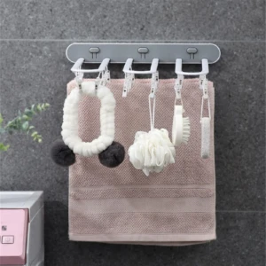 Tendedero plegable gris con 5 ganchos, ideal para colgar toallas y accesorios de baño en espacios reducidos.