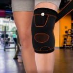 Rodillera deportiva negra con detalles naranjas para entrenamiento en gimnasio.