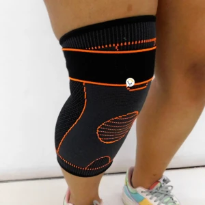 Rodillera deportiva negra con detalles anaranjados, ideal para entrenamiento, vista lateral.