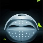 Lámpara LED blanca de 72W para secado de uñas con pantalla digital frontal, diseño curvo y base reflectante sobre fondo oscuro con elementos decorativos.