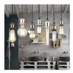 Portalámparas colgantes vintage con bombillas Edison y acabados cobre, oro y plata en baño.