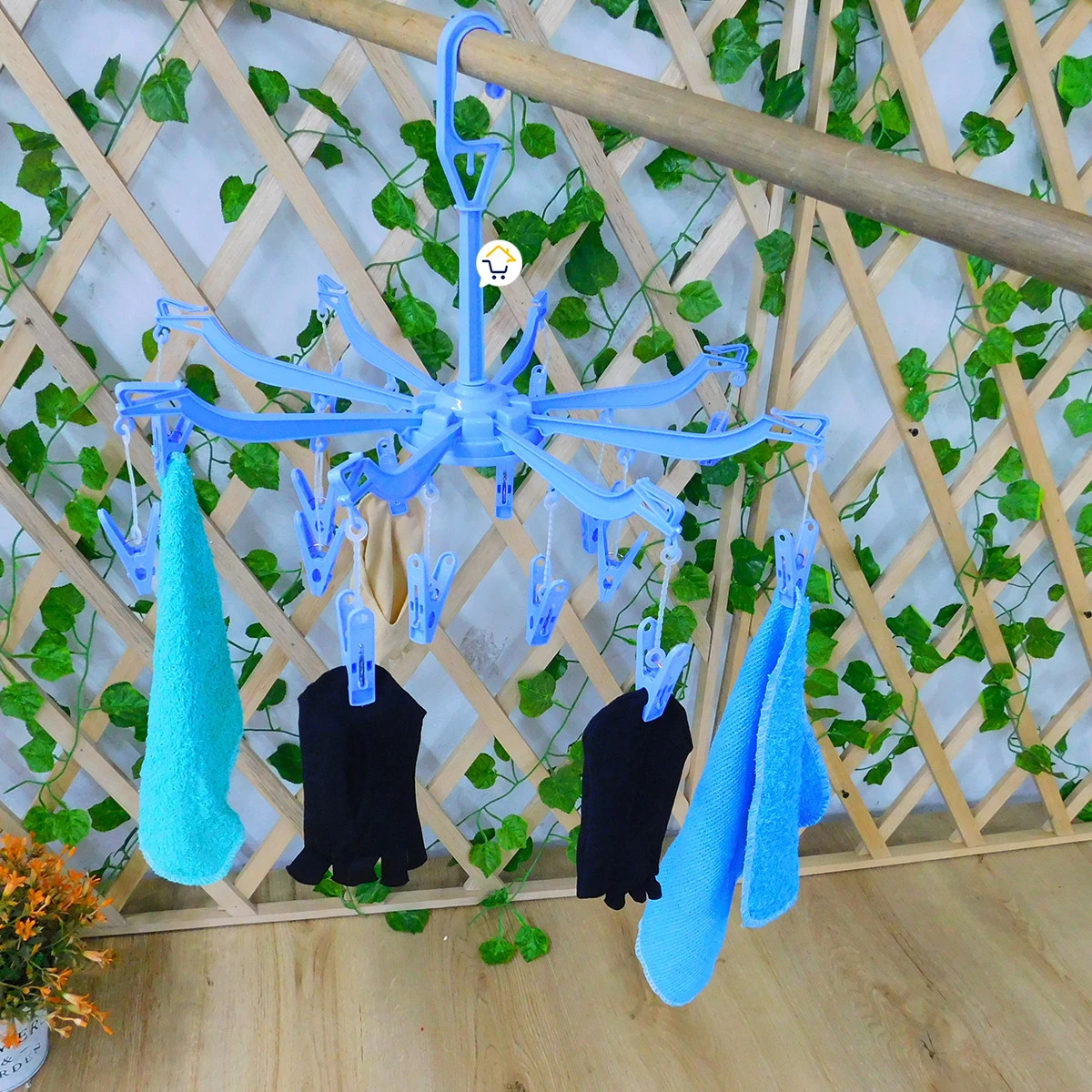 Gancho araña azul con pinzas para secar ropa, cuelga toallas y prendas negras.