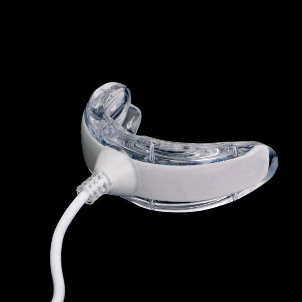 Dispositivo de blanqueamiento dental Luxsmile con férula de silicona transparente conectada a un cable blanco para activación lumínica LED.