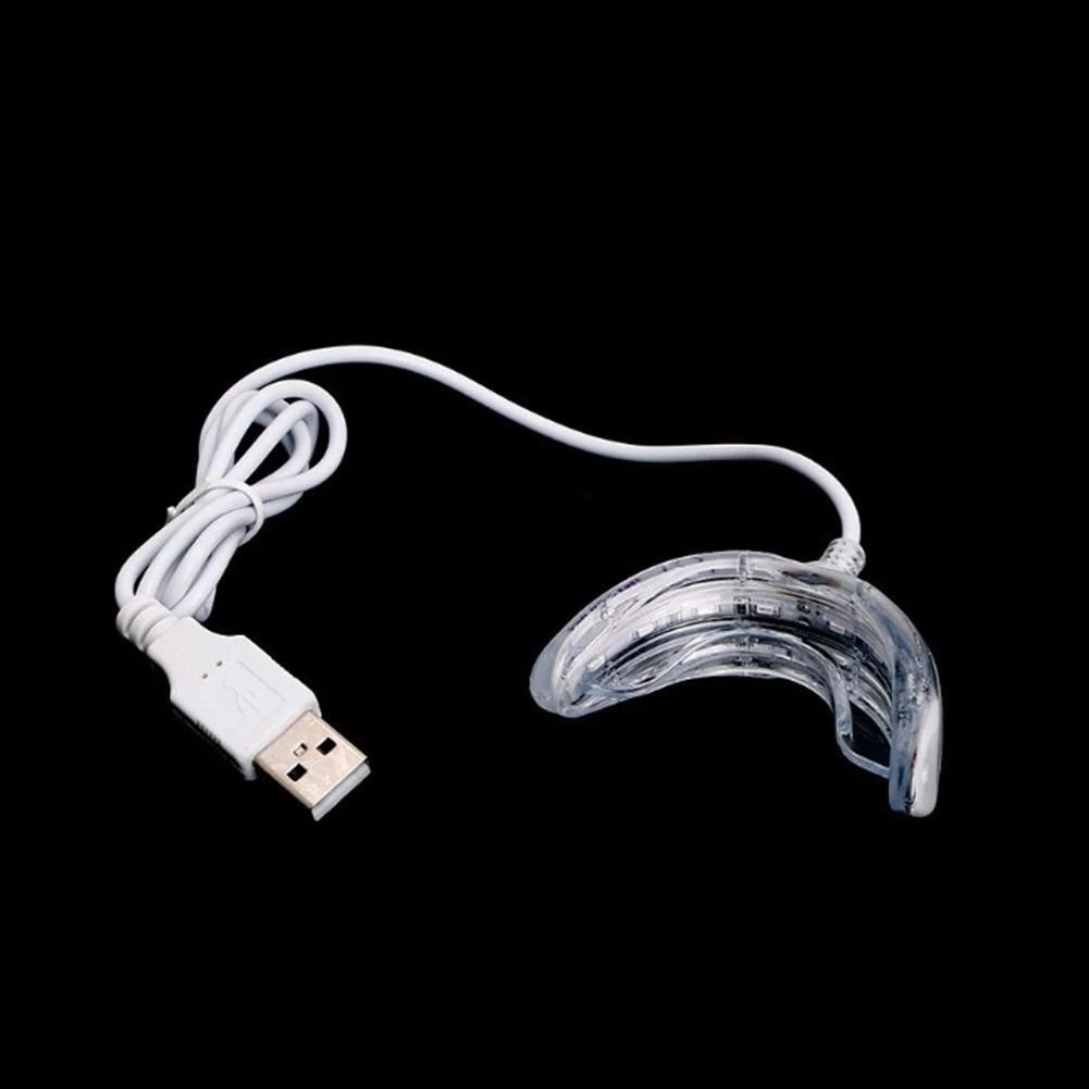 Dispositivo blanqueador dental con luz LED integrada en una boquilla transparente conectada a un cable blanco con conector USB para carga.