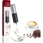 Batidor eléctrico portátil plateado y negro espumando leche junto a café latte y granos.