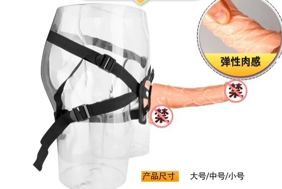 Arnés negro con correas para piernas, sujetando un dildo de silicona texturizada color piel.