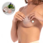 Cubre pezones de silicona color piel, suaves y circulares, que una mujer aplica sobre su pecho. Incluye un detalle superior con el producto en su empaque.