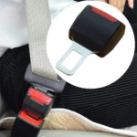 Extensor de cinturón de seguridad para carro con hebilla negra y roja, de tela gris.