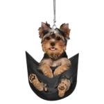 Adorno colgante Yorkshire terrier asomado en bolsillo negro con patas visibles.
