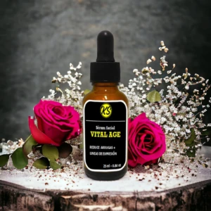 Serum facial Vital Age con gotero en botella ámbar, rodeado de rosas fucsia y flores blancas.