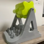 Comedero interactivo para mascotas de rodillo verde con base gris texturizada para ralentizar la alimentación.
