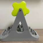 Comedero para mascotas de rodillo, gris con accesorio verde en forma de flor, para ralentizar la alimentación.