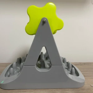 Comedero para mascotas de rodillo, gris con accesorio verde en forma de flor, para ralentizar la alimentación.