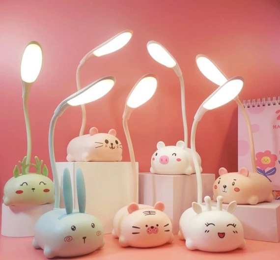 Set de mini lámparas de escritorio LED recargables USB con diseños de animales kawaii, colores pastel y cuellos flexibles, dispuestas sobre soportes.