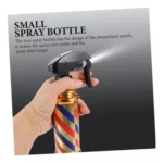 Mano sosteniendo una botella spray para peinar con diseño de franjas diagonales rojas, blancas y azules, estilo barbería, y boquilla negra de presión.