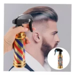 Botella spray profesional para barbería con diseño de poste clásico tricolor y acabado dorado, usada por una mano para rociar agua sobre el cabello.