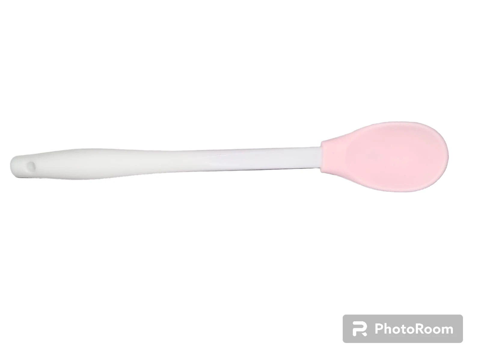 Cuchara de silicona con punta redonda color rosa suave y mango largo de plástico rígido blanco, ideal para alimentación infantil o repostería.