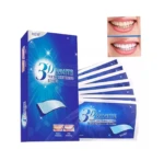 Caja azul de bandas blanqueadoras 3D White con muestra de resultados antes y después, acompañada de varios sobres individuales del tratamiento dental.