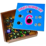 Juego de mesa de integración con canicas de colores, dado azul y tapa con orificios numerados para encestar.