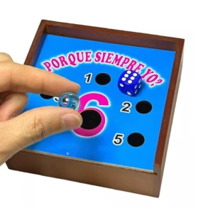 Juego de mesa de integración azul con dados, canica y números 1, 2, 5. Mano sosteniendo canica.