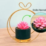Suculenta artificial rosa en maceta verde con marco dorado y detalle de texto "Detalles Hiperrealistas".