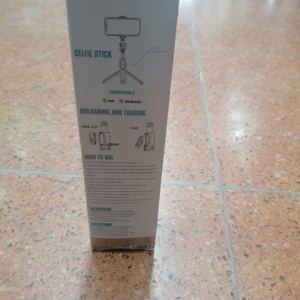 Trípode selfie gris para celular con instrucciones de uso en español, compatible con iOS y Android.