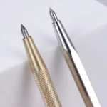 Dos punzones para corte de vidrio, uno dorado texturizado y otro plateado liso.