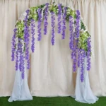 Arco decorativo de glicinias colgantes moradas y blancas, ideal para bodas y eventos.