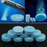 Pastillas efervescentes azules para limpia parabrisas, en primer plano apiladas y en acción disolviéndose.