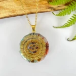 Colgante orgonita redondo con símbolo Om dorado y cuarzos multicolores.