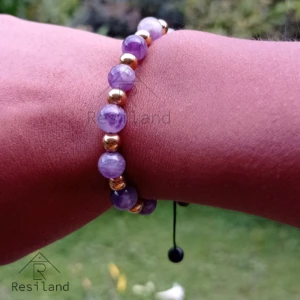 Pulsera de amatista y cuentas doradas en muñeca, ideal para el uso diario.