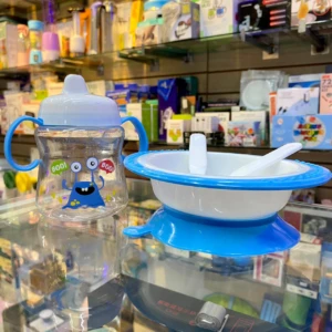 Set de vajilla para bebé con plato succionador y vaso entrenador con diseño de monstruo azul.