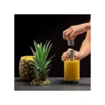 Pelador de piña en acción: manos extraen espiral de fruta amarilla lista para servir.