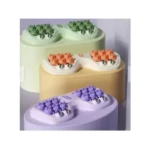 Masajeador manual de pies con rodillos en forma de ositos, disponible en verde, naranja y morado.