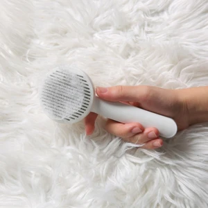 Cepillo blanco para mascotas recogiendo pelo sobre alfombra peluda blanca, ideal para limpieza.