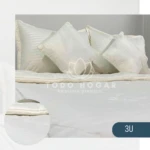 Plumón nórdico blanco con textura de rayas, dos almohadas decorativas blancas y manta de cama.