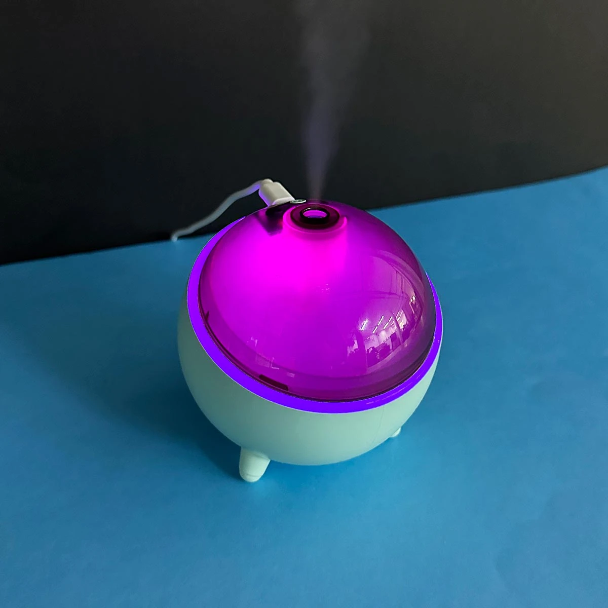 Humidificador Q803 esférico color menta con tapa brillante morada, emitiendo vapor y luz ambiental.
