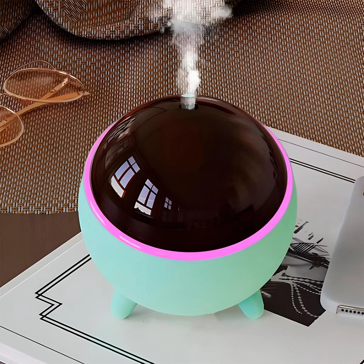 Humidificador Q803 redondo verde menta con luz rosa, vapor difuso y fondo tejido.
