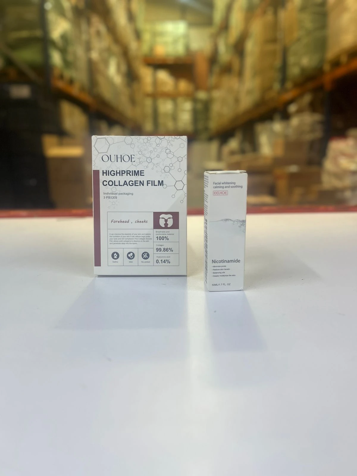 Caja de mascarillas de colágeno OUHOE y serum facial de nicotinamida, enfoque en el empaque y detalles de ingredientes.