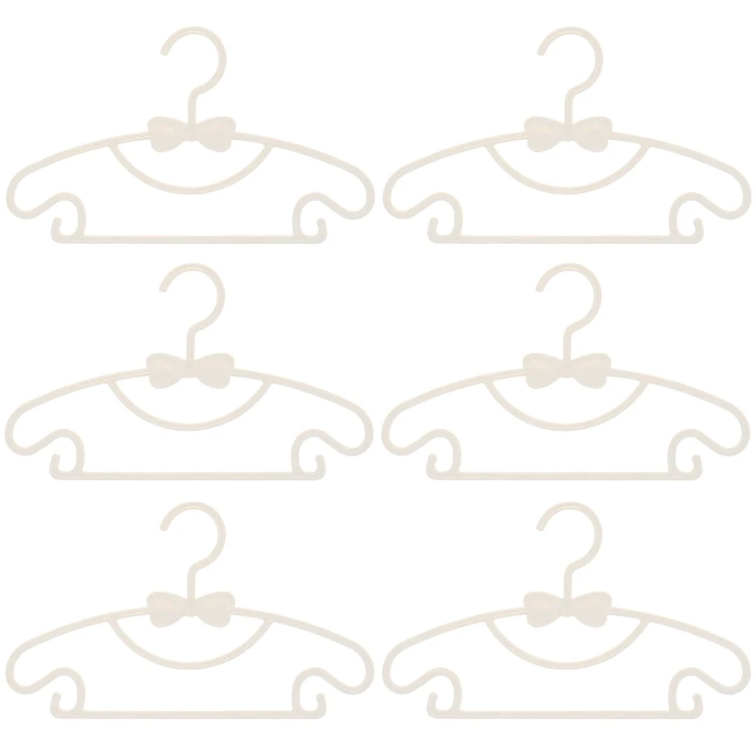 Seis ganchos beige flexibles para ropa de bebé con forma de coche, decorados con un moño, ideales para organizar.