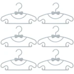Seis ganchos flexibles para ropa de bebé en color gris con diseño de moño, ideales para organizar prendas infantiles.