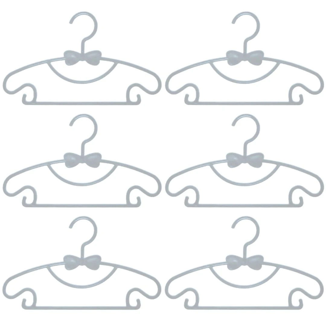 Seis ganchos flexibles para ropa de bebé en color gris con diseño de moño, ideales para organizar prendas infantiles.