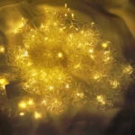 Cortina de luces LED navideñas de 3 metros con 12 flores transparentes y luz cálida.