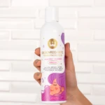 Desenredante termoprotector capilar en envase blanco con diseño de rostro femenino, sujetado por una mano.