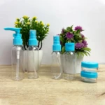 Set de 6 envases transparentes con tapas y dispensadores azules para viaje, ideal para líquidos y cremas.