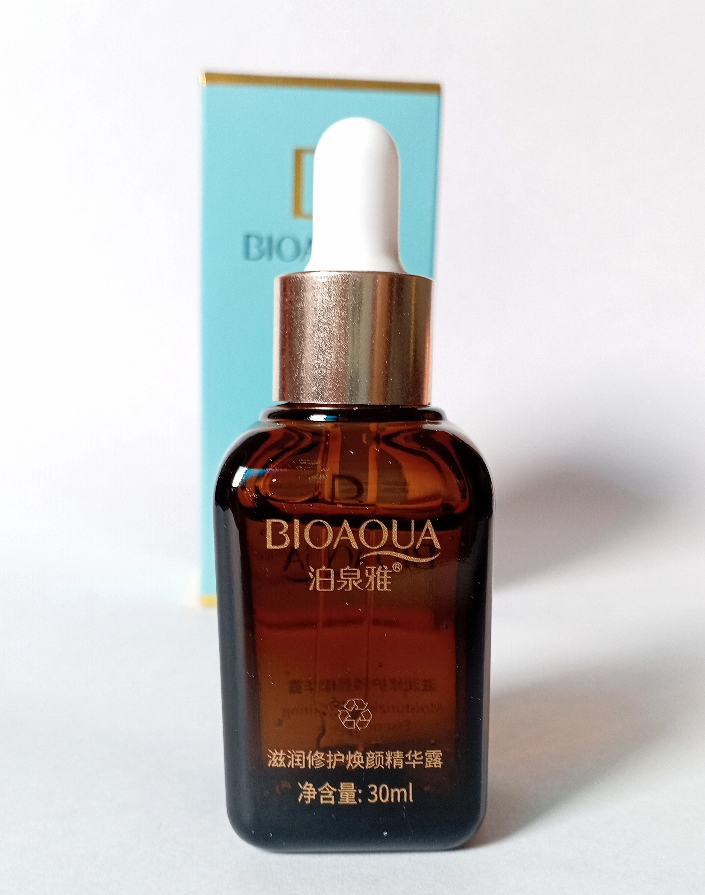Serum BIOAQUA ámbar 30ml con gotero dorado, caja azul al fondo.
