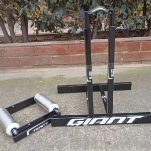 Rodillos traseros para bicicleta Giant y Trinity, negros, con soporte y rodillos metálicos en exterior de ladrillo.