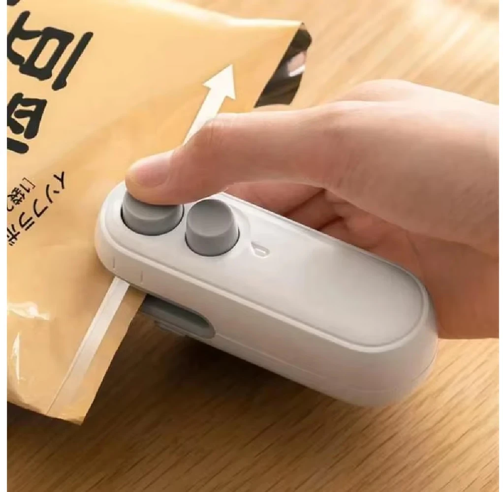 Mini sellador de bolsas blanco 2 en 1 en uso, sellando paquete marrón.